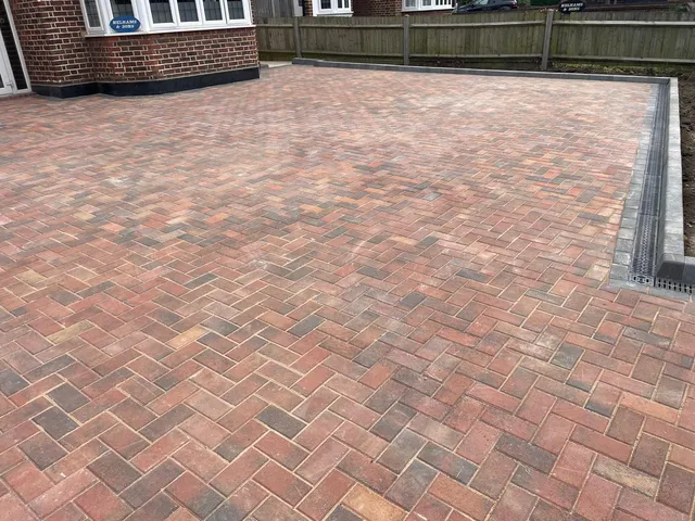 Close-up of finished block paving in a herringbone pattern with a contrasting edge and drainage channel