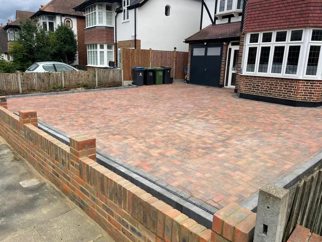 Finished block paved driveway in Epsom viewed from the side, with a new brick boundary wall