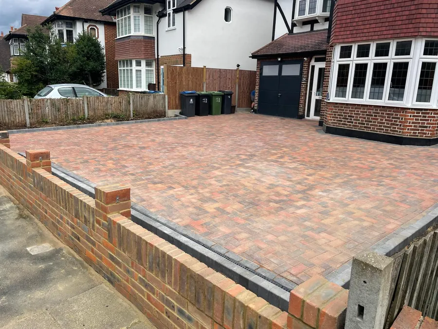 Finished block paved driveway in Epsom viewed from the side, with a new brick boundary wall