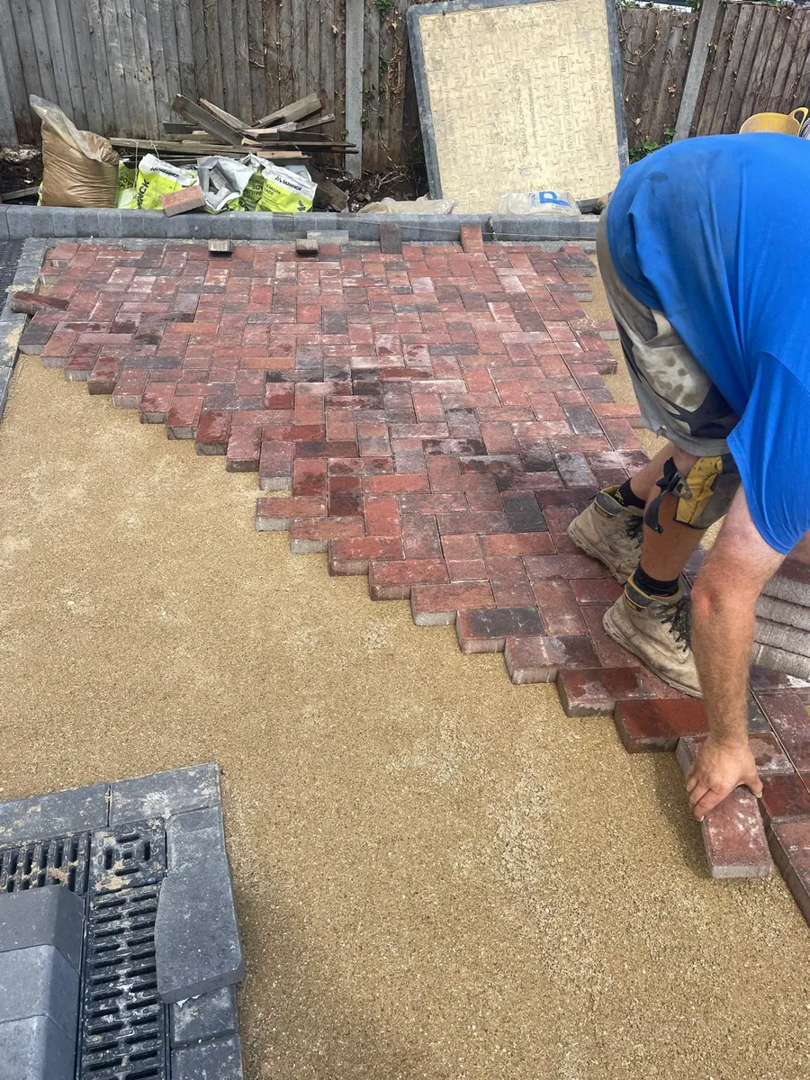 Block paving driveway installation in progress, with herringbone blocks being laid onto a prepared sub-base
